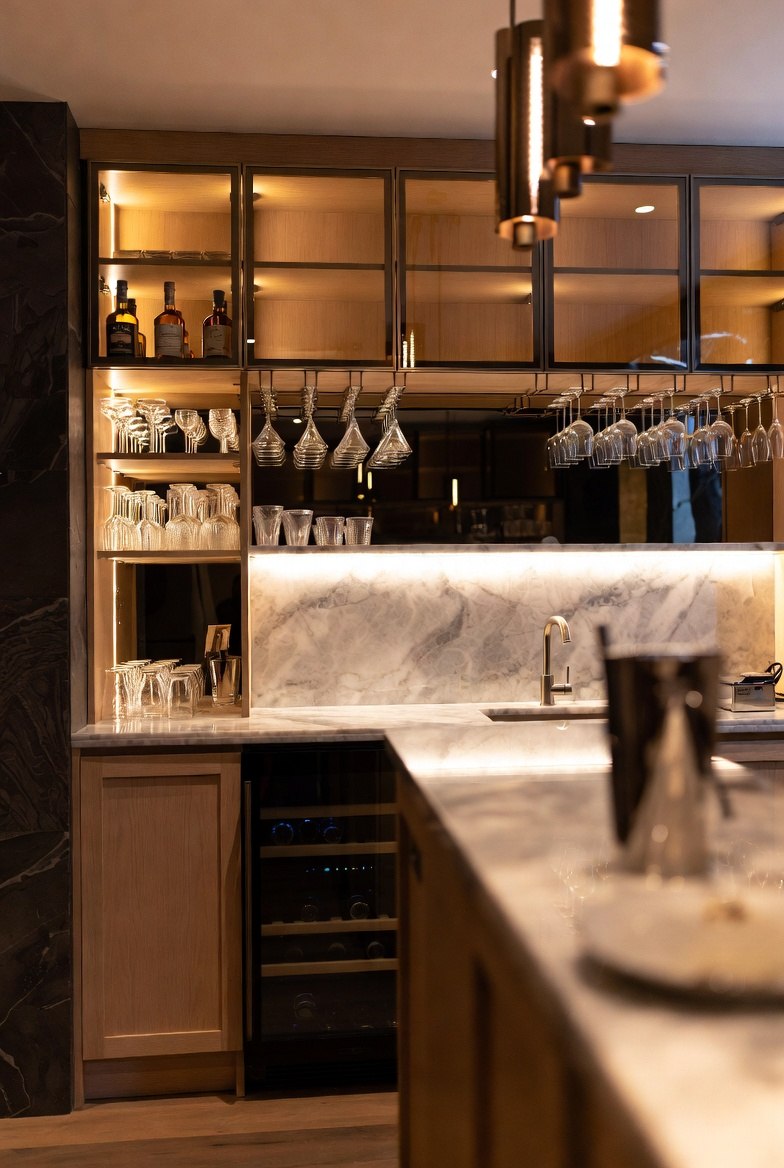 Custom
   oak home bar with glass-front display cabinets and marble backsplash in a luxury Toronto home